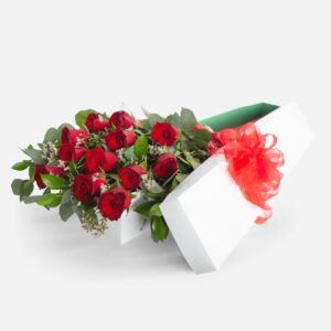 The Velvet Reserve Red roses and greenery in a white gift box with a red bow.