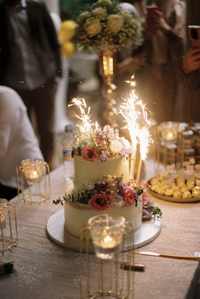A beautifully decorated celebration cake with sparklers, surrounded by elegant decor, perfect for festive gatherings.