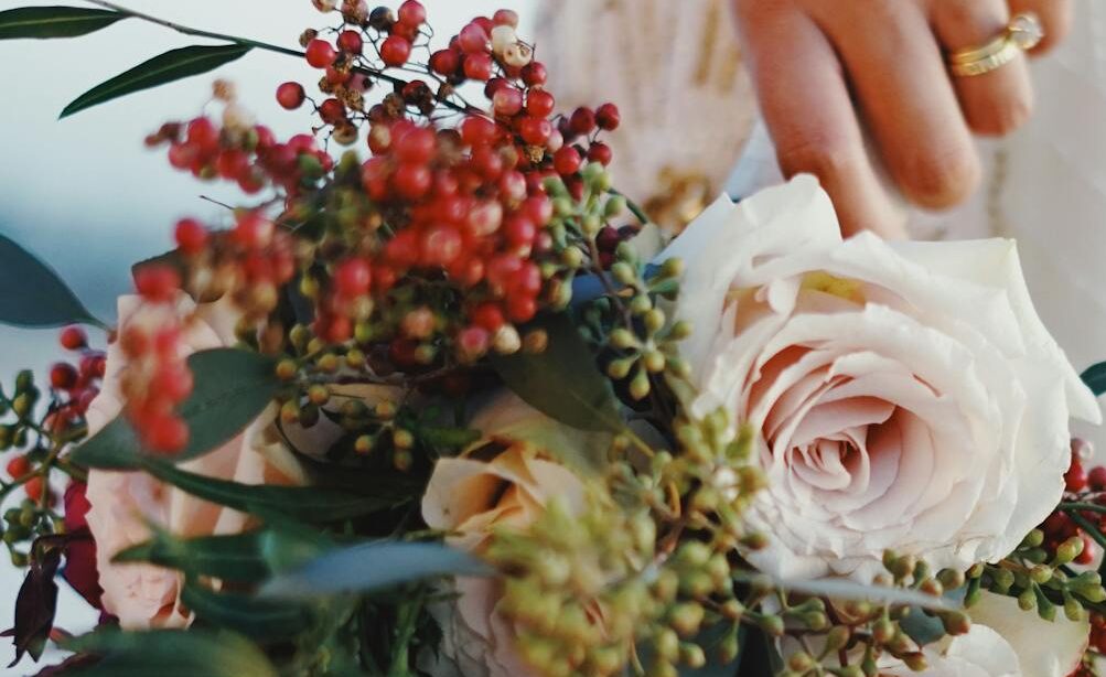 A bride holding a beautiful floral bouquet, showcasing elegance and tradition on her wedding day.
