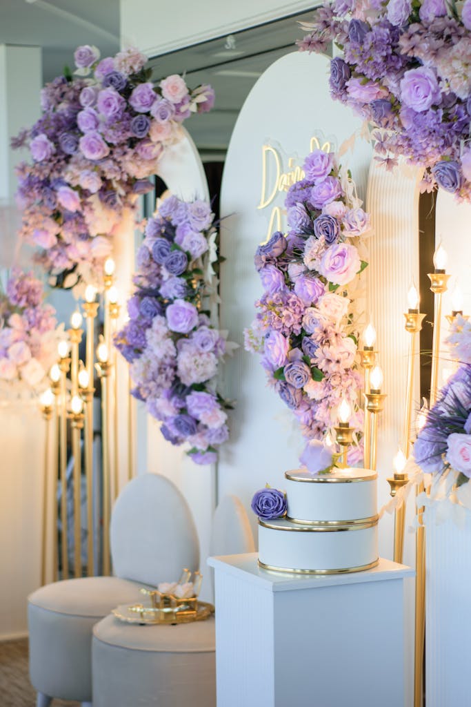 Stunning wedding decor featuring lavender roses, elegant lighting, and cake arrangement.