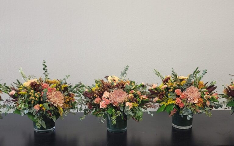 Five floral arrangements on a table.