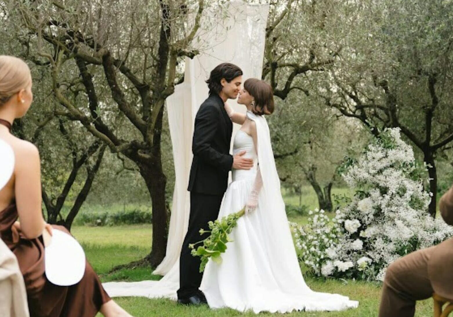 A beautiful outdoor wedding ceremony in Torroella de Montgrí, Spain with the couple and guests.