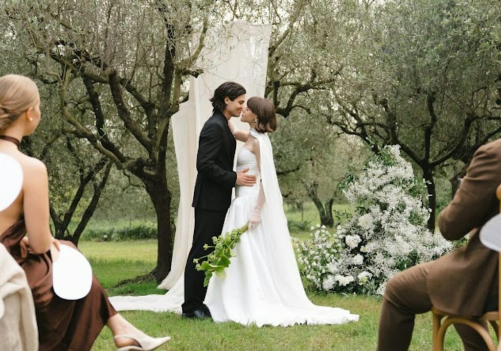 A beautiful outdoor wedding ceremony in Torroella de Montgrí, Spain with the couple and guests.