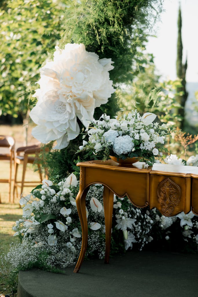 Exquisite outdoor wedding setup with floral decorations and ornate wooden table.