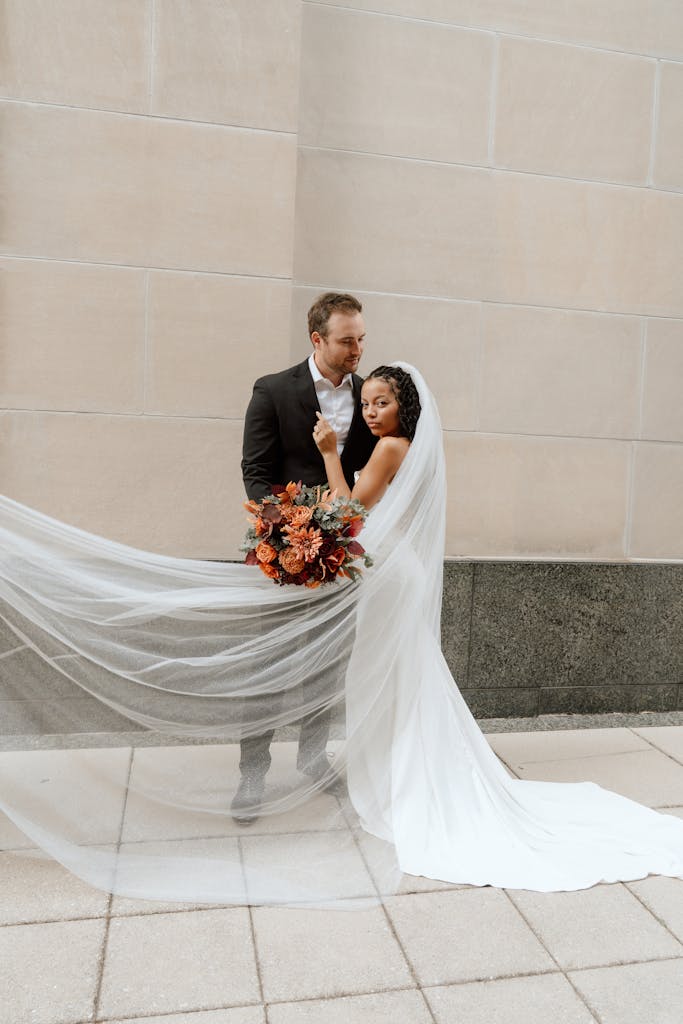 Stunning wedding couple portrait in Orlando with flowing veil and vibrant bouquet.